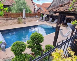 a swimming pool in a backyard with a swing at Le Clos Bleu - Gite Rural in Schillersdorf