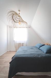 Een bed of bedden in een kamer bij Le Clos Bleu - Gite Rural