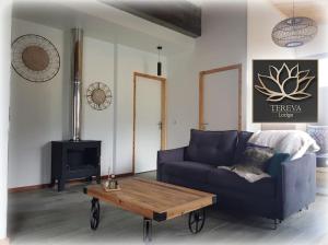 Sala de estar con sofá azul y mesa de centro en Téréva Lodge - La villa de standing, en Cilaos