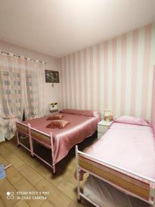 ナポリにあるA&C SweetHomeのストライプ壁の客室内のベッド2台