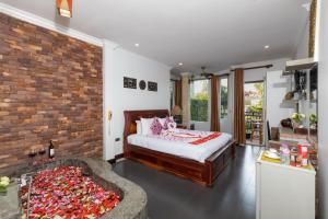 ein Schlafzimmer mit einem Bett und einer Ziegelwand in der Unterkunft The Five Senses Boutique Hotel in Siem Reap