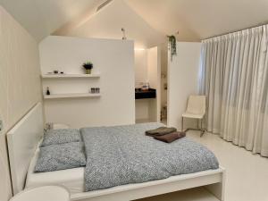 um quarto branco com uma cama e uma cadeira em Luxurious villa during tomorrowland em Hemiksem