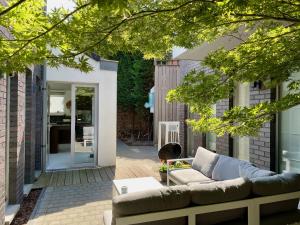 Luxurious villa during tomorrowland في Hemiksem: فناء مع أريكة وطاولة