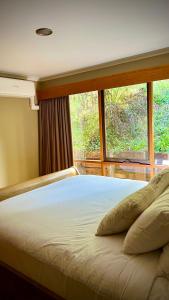 Bett in einem Zimmer mit einem großen Fenster in der Unterkunft Melbourne Topview Villa in Dandenong ranges near Skyhigh in Kalorama