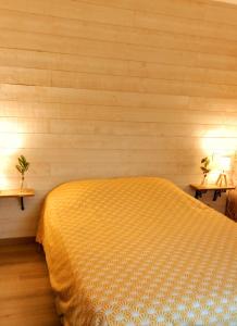 - une chambre avec un lit et deux lampes sur deux tables dans l'établissement Le cottage du Marais., à Houlle