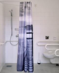 a shower curtain in a bathroom with a toilet at Motel Home Wittenau in Berlin