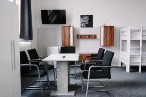 a dining room with a table and black chairs at Motel Home Wittenau Berlin in Berlin