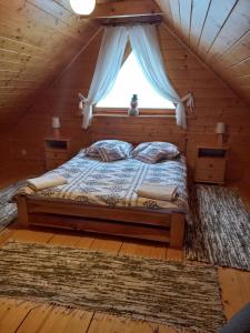 ザボヤにあるDomek drewniany simonka zawojaの窓付きのログキャビンのベッド1台分です。