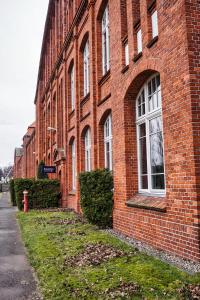 a brick building with a red fire hydrant in front of it at Motel Home Wittenau in Berlin