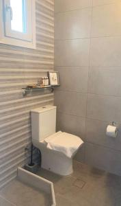 uma casa de banho com um WC branco num quarto em La Main Street suite em Andiparos