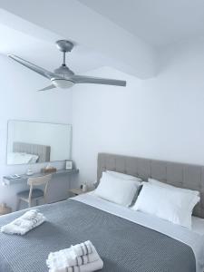 um quarto com uma cama e uma ventoinha de tecto em La Main Street suite em Andiparos