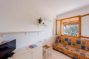 a living room with a couch and a window at Villino Garden & Pool in Marina dʼAndora