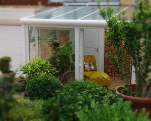 a screened in porch with a yellow chair and plants at Casa-Catalina in Heddesheim