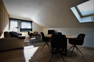 sala de estar con mesa, sillas y sofá en Alpin Haus Berwang, en Berwang