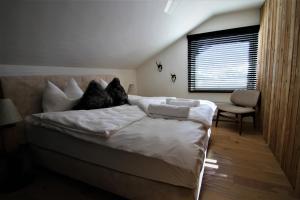 um quarto com uma cama com lençóis brancos e almofadas em Alpin Haus Berwang em Berwang