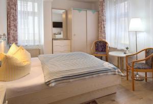 een slaapkamer met een bed en een tafel en stoelen bij Ferienzimmer in der Villa Ostseelilie in Sassnitz