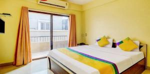 1 dormitorio con cama y ventana grande en Coronet Luxurious Apartment en Pune