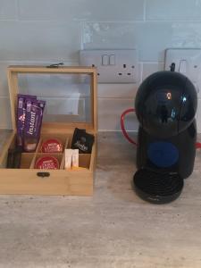 a tea kettle next to a box and a mirror at The Mews in Newbridge