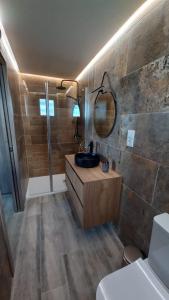 La salle de bains est pourvue d'un lavabo et d'un miroir. dans l'établissement Airen Suites, à Chinchón