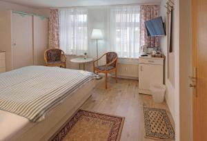 a bedroom with a bed and a table and chairs at Ferienzimmer in der Villa Ostseelilie in Sassnitz +6 photos