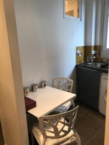 cocina con mesa, sillas y fregadero en Sweet Room 15, en París