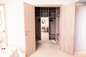 einen Schrank mit Holztüren in einem Zimmer in der Unterkunft Lilium Apartment in Kos-Stadt