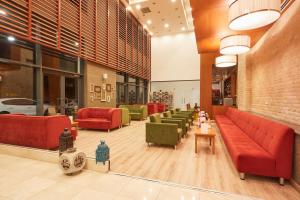a lobby with red couches and green chairs at Park Dedeman Denizli in Denizli