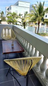 einen Tisch und Stühle auf einem Balkon mit Blick auf das Wasser in der Unterkunft Minh Phu Quoc hotel 1 minute walking to beach in Phu Quoc
