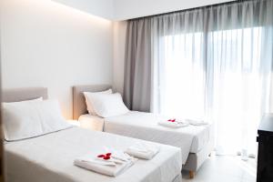 una camera d'albergo con due letti con rose rosse di Lilium Apartment a Città di Kos