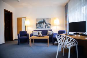 a living room with a couch and a table and chairs at Park Hotel in Schweinfurt