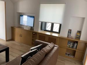 a living room with a couch and a flat screen tv at Casa rural Maila in Malpartida de Cáceres