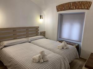 2 camas con toallas en un dormitorio en Casa rural Maila, en Malpartida de Cáceres