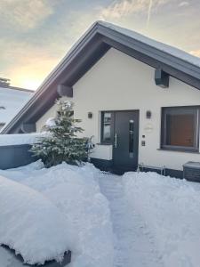 una casa cubierta de nieve con un árbol de Navidad en Murperle en Sankt Michael im Lungau