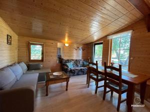 a living room with a couch and a table at Resort by Nava Lake in Aukštadvaris