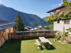 une table de pique-nique dans l'herbe à côté d'un bâtiment dans l'établissement App. Monte Pore - Agriturismo La Majon, à Colle Santa Lucia