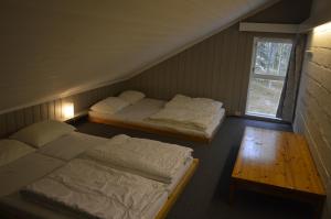 een kamer met 2 bedden, een tafel en een raam bij 14-Nasjonalpark, sykling, fisking, kanopadling, skogs- og fjellturer in Trysil