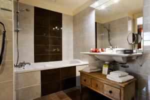 a bathroom with a sink and a tub and a shower at Almoria Hôtel & SPA in Deauville +37 photos