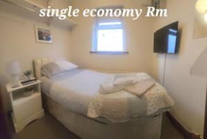 - une petite chambre avec un lit et des serviettes dans l'établissement AVALON HOUSE, à Galway
