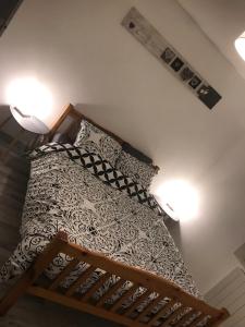 łóżko w sypialni z dwoma światłami na ścianie w obiekcie Maisonnette cosy à Châtillon-Coligny w mieście Châtillon-Coligny