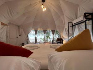 een slaapkamer met 2 bedden in een tent bij Touch Glamping Koh Yao Noi ทัช แกรมปิ้ง เกาะยาวน้อย in Ko Yao Noi