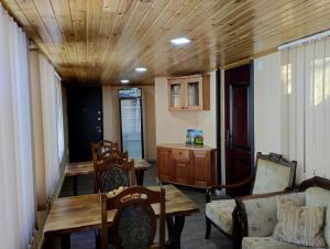 a living room with a wooden ceiling and a table and chairs at Spardishi tower in Mestia