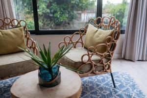 a living room with two chairs and a table with a plant at The Tree House Boutique Hotel by The Living Journey Collection in Cape Town
