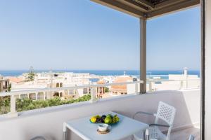 balcón con mesa y vistas al océano en Menta City Boutique Hotel, en Rethymno
