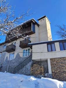 un edificio con la neve davanti di Spardishi tower a Mestia