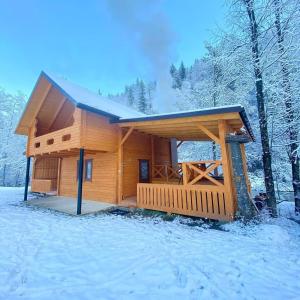 una cabaña de madera en la nieve en el bosque en Гостинний двір "Софія", en Krasnik