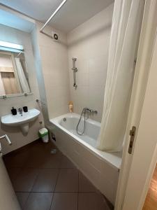 bagno con vasca e lavandino di Nevena Belville Apartments a Belgrado