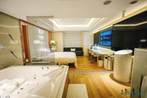 Habitación de hotel con cama y bañera en MMMotel en Taoyuan