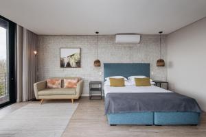 a bedroom with a large bed and a chair at The Tree House Boutique Hotel by The Living Journey Collection in Cape Town