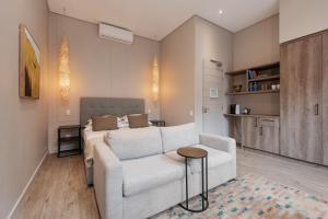 a living room with a white couch and a bed at The Tree House Boutique Hotel by The Living Journey Collection in Cape Town