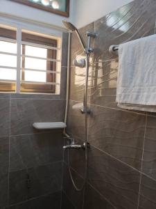 y baño con ducha y ventana. en Chez Gero, en Cotonou